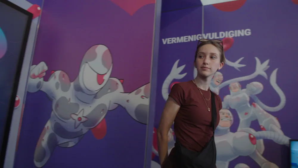 Visitor in front of the illustrated panel walls on the booth
