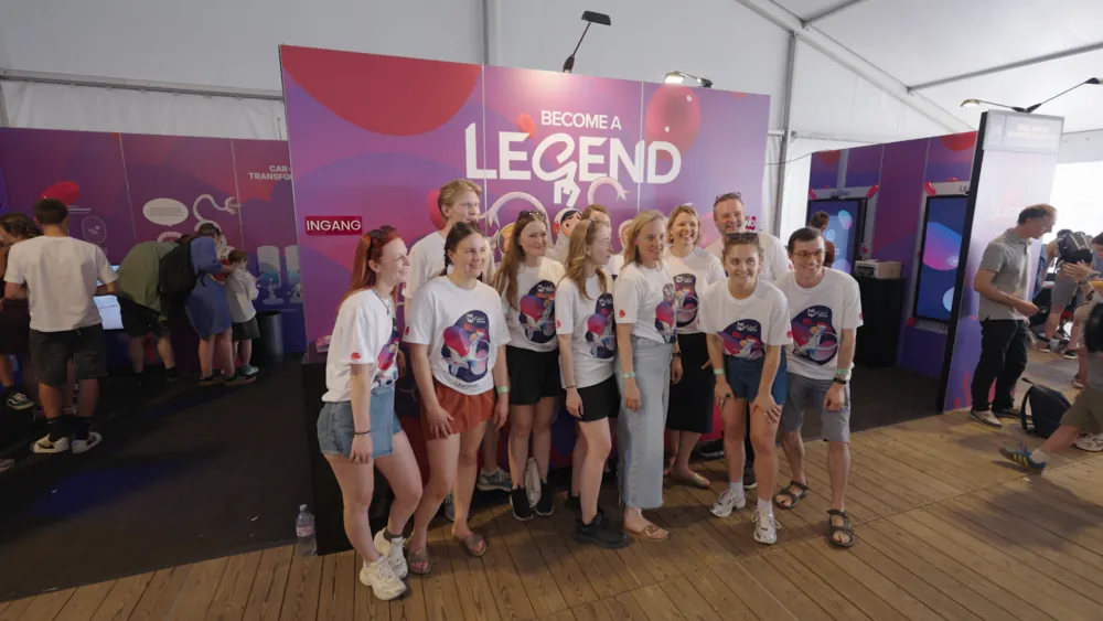 The crew team in front of the Become a Legend booth wall